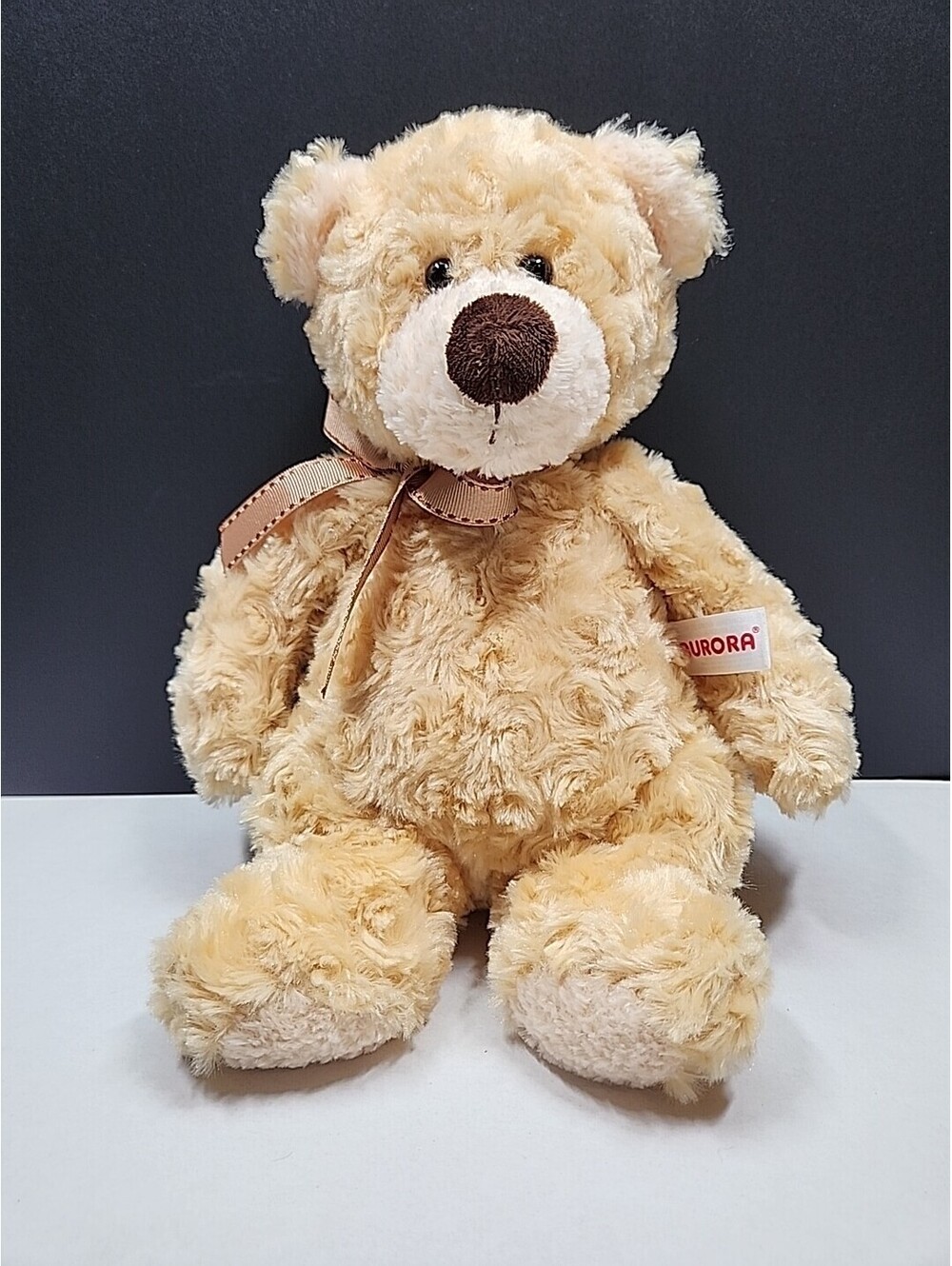 Aurora Sitting teddy bear with brown Bow, 9" Sitting, 11" Tall.